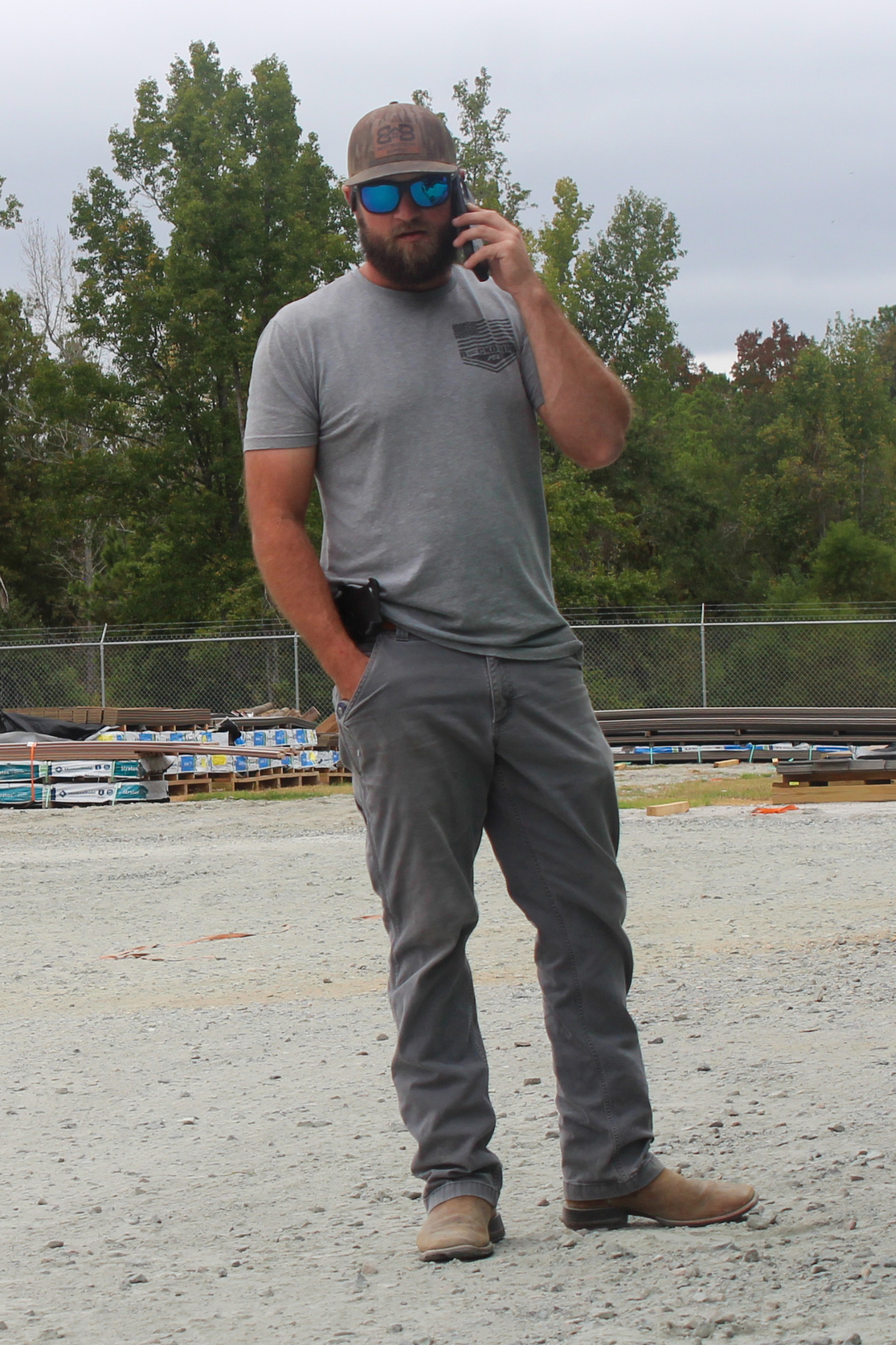 Dallas Hollomon speaking on a phone in the Best Builders Supply yard